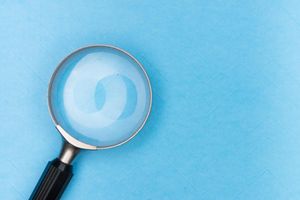 a magnifying glass sitting on a blue surface